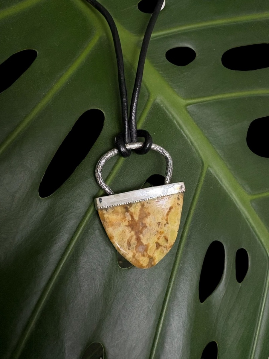 esőerdő jáspis nyaklánc zöld levélen elhelyezve felülnézet természetes fényben