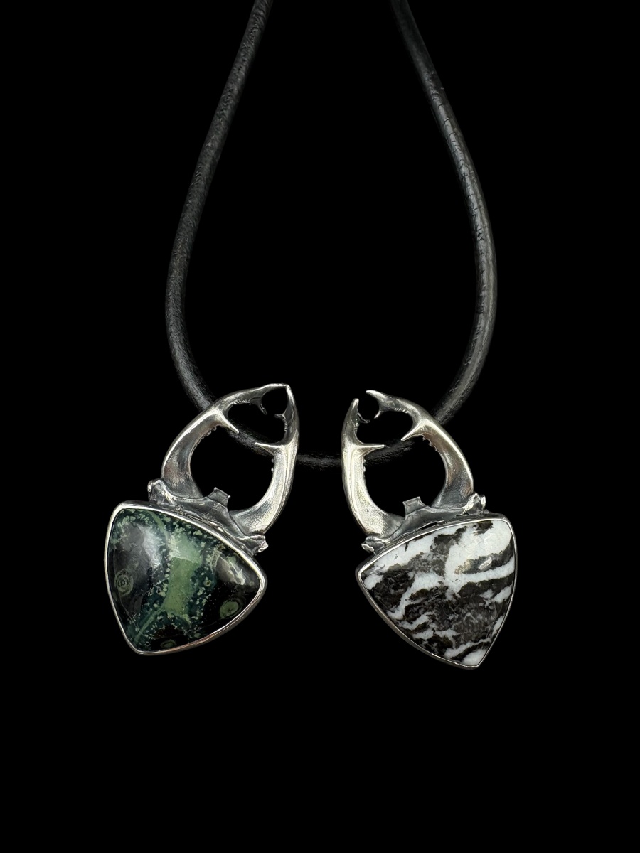 kézműves szarvasbogár formájú ezüst medál nyakláncon két különböző háromszög alakú kővel fekete háttéren