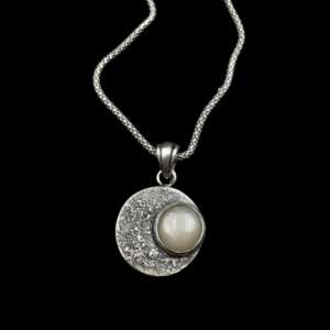 Szeléné nyaklánc 925 ezüst holdkő medállal fekete háttéren lefektetve közelről